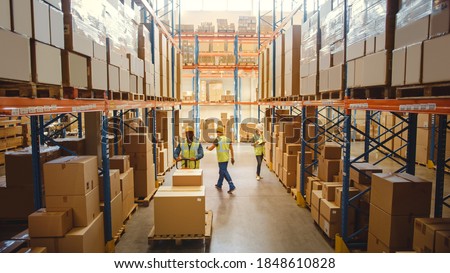 Retail Warehouse full of Shelves with Goods in Cardboard Boxes, Workers Scan and Sort Packages, Move Inventory with Pallet Trucks and Forklifts. Product Distribution Logistics Center. Elevated Shot ストックフォト © 
