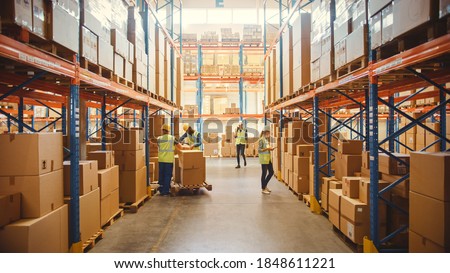 Retail Warehouse full of Shelves with Goods in Cardboard Boxes, Workers Scan and Sort Packages, Move Inventory with Pallet Trucks and Forklifts. Product Distribution Delivery Center.