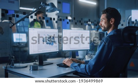 Industrial Engineer Solving Problems, Working on a Personal Computer, Two Monitor Screens Show CAD Software with 3D Prototype of Eco-Friendly Electric Engine Concept.