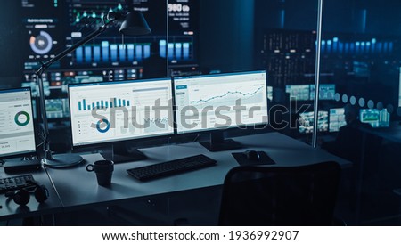 Two Digital Computer Screens with Financial Analytical Data in Modern Monitoring Office. Control Room with Finance Specialists Sit in Front of Computers.