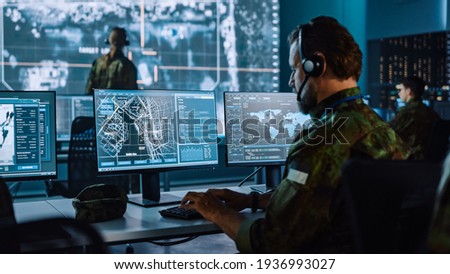 Military Surveillance Officer Working on a City Tracking Operation in a Central Office Hub for Cyber Control and Monitoring for Managing National Security, Technology and Army Communications. Сток-фото © 