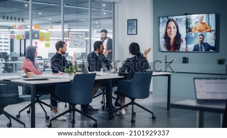 Businesspeople do Video Conference Call with Big Wall TV in Office Meeting Room. Diverse Team of Creative Entrepreneurs at Big Table have Discussion. Specialists work in Digital e-Commerce Startup 商業照片 © 