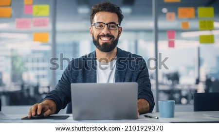 Modern Office: Portrait of Stylish Hispanic Businessman Works on Laptop, Does Data Analysis and Creative Designer, Looks at Camera and Smiles. Digital Entrepreneur Works on e-Commerce Startup Project Stock foto © 