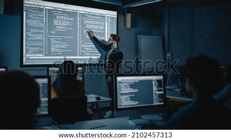 Teacher Giving Computer Science Lecture to Diverse Multiethnic Group of Female and Male Students in Dark College Room. Projecting Slideshow with Programming Code. Explaining Information Technology. Imagine de stoc © 