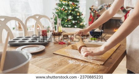 Similar – Image, Stock Photo Anonymous female cook rolling dough while using pasta machine