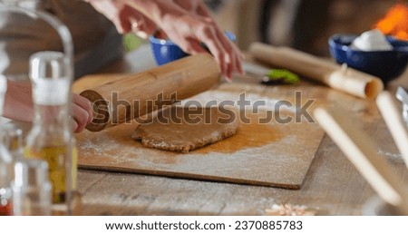 Similar – Image, Stock Photo Anonymous female cook rolling dough while using pasta machine