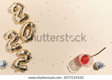 beige festive background for new year or christmas with pink drinks wine, juice, punch, champagne and foil gold balloons in the shape of 2022 Photo stock © 