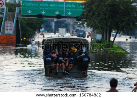 BANGKOK THAILAND - OCTOBER 30 : Soldiers help flood victims evacuate by truck after the flood water is getting higher on October 30,2011 Bangkok, Thailand.