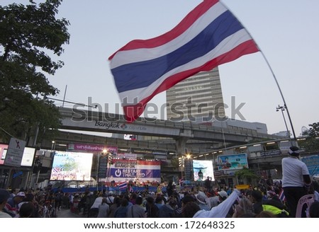BANGKOK - JANUARY 21 : Protester applauds with Thai flag in an anti-government rally at  Pathumwan junction on January 21, 2014 in Bangkok Thailand.