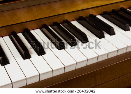 Close up of piano keys from a walnut piano.