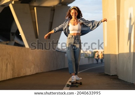 Similar – Image, Stock Photo Relaxed stylish skater riding skateboard along pavement