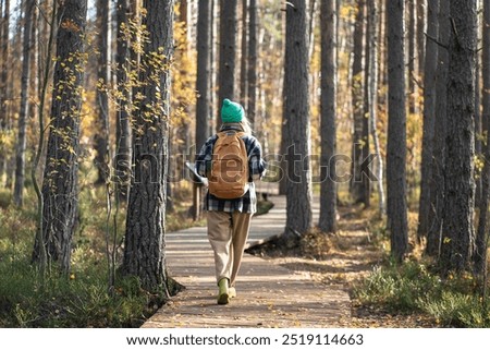Similar – Image, Stock Photo Woman with backpack wandering around a forest on autumn cold day