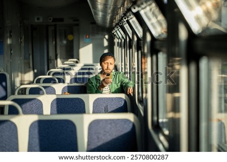 Similar – Image, Stock Photo Concentrated male passenger using laptop in train