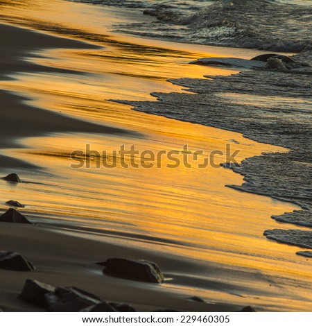 Lake Superior, Michigan - September 30, 2011:  waves reflecting sunset on the shore of Lake Superior