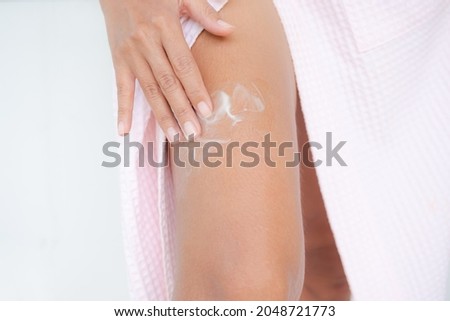 Woman applying lotion skin serum cream on leg after shower. Moisturizer skin care for moisturized reduce wrinkles and protection UV A, B. cosmetic for beauty and good health concept. skin tan. Stock fotó © 