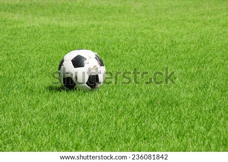 Old Soccer ball or old football ball on green field