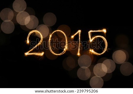 Happy New Year 2015 sparkle firework writing with dirty gold colorful lights blur bokeh background