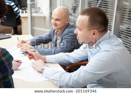Business partners discussing ideas at meeting, neutral background