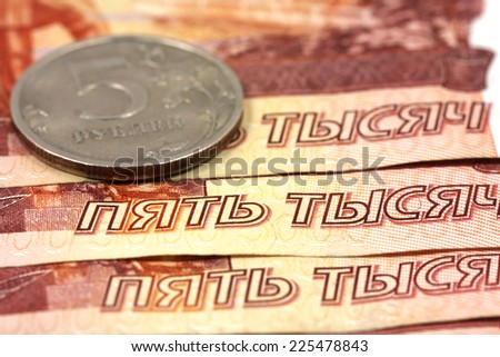 five thousand ruble notes and five-ruble coin close-up