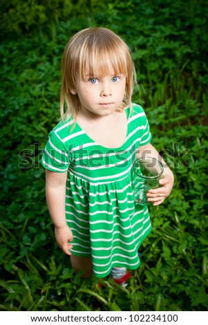 Little girl holding glass jar with snails
