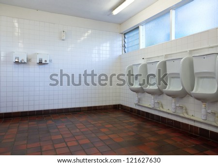 Empty public lavatory with urinals and hand dryers