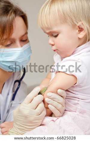 Doctor giving a child an intramuscular injection in arm