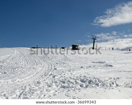 Ski tracks in the snow with a ski lift