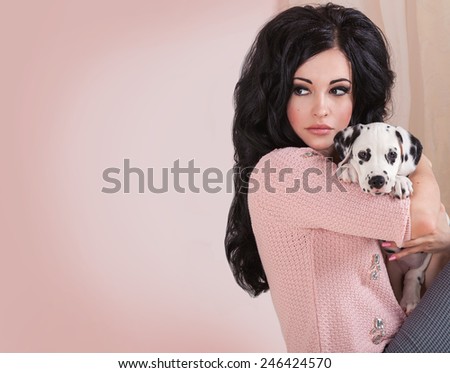 Brunette girl protecting dalmatian puppy dog