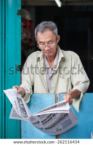 SAIGON, VIETNAM December 30, 2014: unidentified man reading the newspaper. Reading newspapers is a beautiful culture in Vietnam.