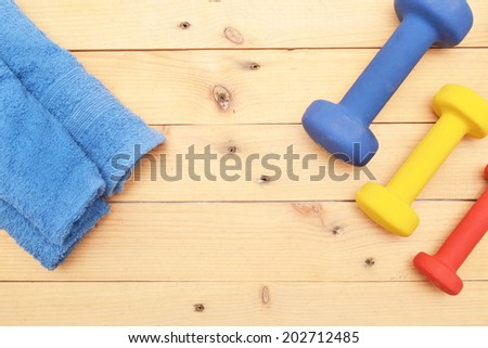 Towel and dumbbells on wood
