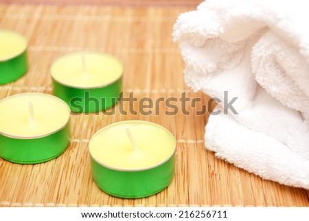 Candles, zen stones and towel on wood