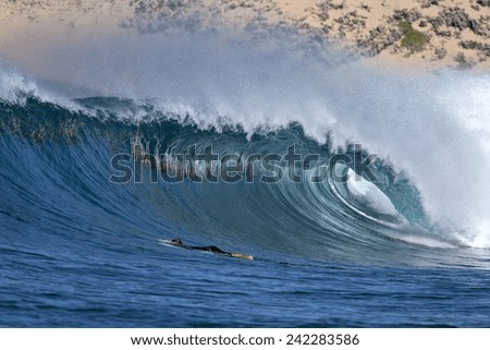 A surfer pushes under a tube on an ocean wave.