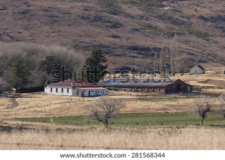 An old farmhouse sits in a valley in the South African countryside.
