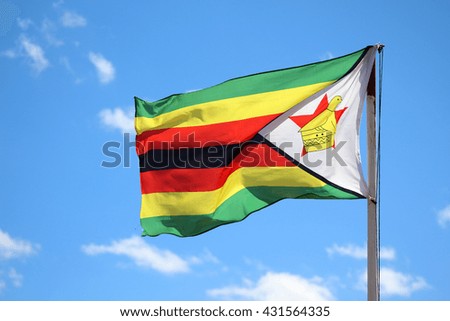 Photograph of the flag of Zimbabwe fluttering in the wind against a blue sky on a sunny day. Zdjęcia stock © 