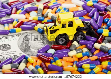 Industrial tractor toy rake up pills (installation on the theme of modern medicine trends)