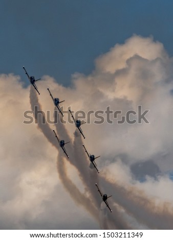 Formation of small airplanes make an aerobatic display with smoke trails at the airshow Stok fotoğraf © 