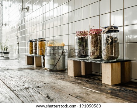 Cans with different grocery items on wooden kitchen table