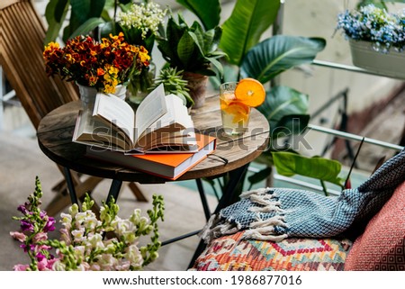 Reading books in summer at a beautiful terrace or cozy balcony full of green plants. Imagine de stoc © 