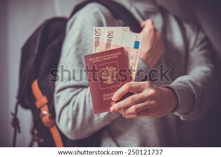 Tourist person holds russian passport and euro bills. Toned picture