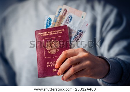 Russian passport and russian rouble bills in hand