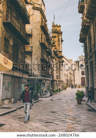 PALERMO, ITALY - MARCH 14, 2015: Unidentified person walking by steet in old city centre of Palermo, Italy. Toned picture