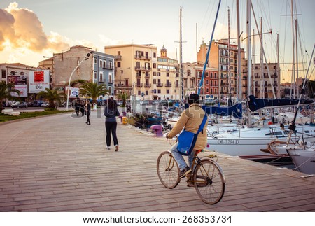 PALERMO, ITALY - MARCH 14, 2015: People walking and cycling along La Cala bay in Palermo, Italy