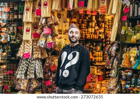 NAPLES, ITALY - MARCH 20, 2015: Vendor stands near grocery shop with classical italian food in the old center of Naples, Italy.