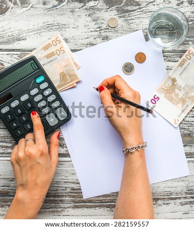 Woman counting euro money with calculator. Business concept. Top view