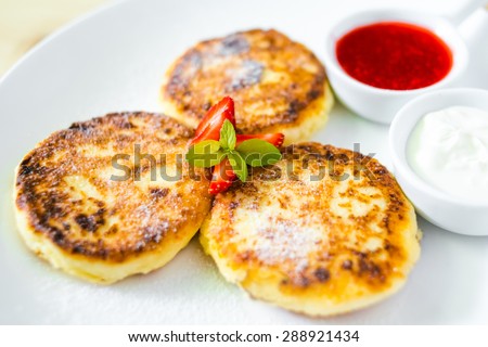 Cottage cheese pancakes with sour cream and strawberry sauce