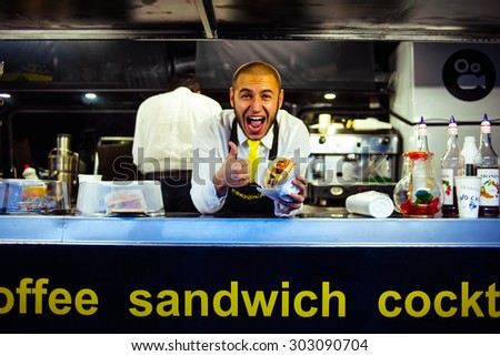 SAINT-PETERSBURG, RUSSIA - JULY 25, 2015: Young seller of burgers in a food truck in Saint-Petersburg, Russia.