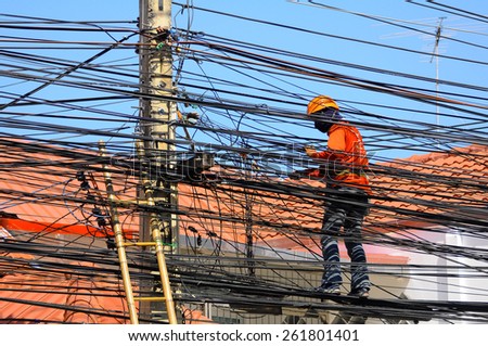 Pattaya, Thailand - Mar 9, 2015 - An unidentified man works on electric wires to install the household cable wires network