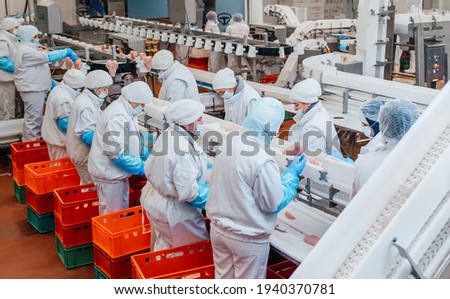 Production line in the food factory.Factory for the production of food from meat.Industrial equipment at a meat factory.Automated production line in modern food factory.People working. Foto stock © 