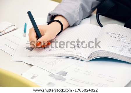 Young girl studying using pen and a notebook, preparation for SAT, preparation for ACT, CLT,  preparation for math exam, standardized test preparation Stok fotoğraf © 