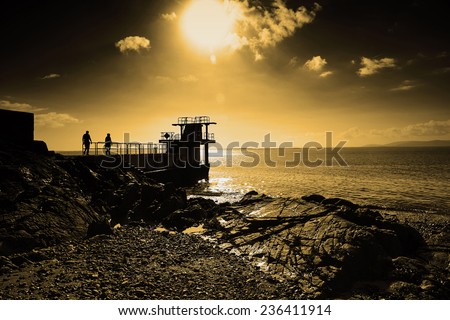 Blackrock Diving Tower is a pier with several diving platforms at different levels and is located at the end of Salthill\'s promenade with Galway Bay in the background
